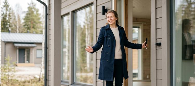 Kiinteistönvälittäjä avaamassa ovea asuntoon